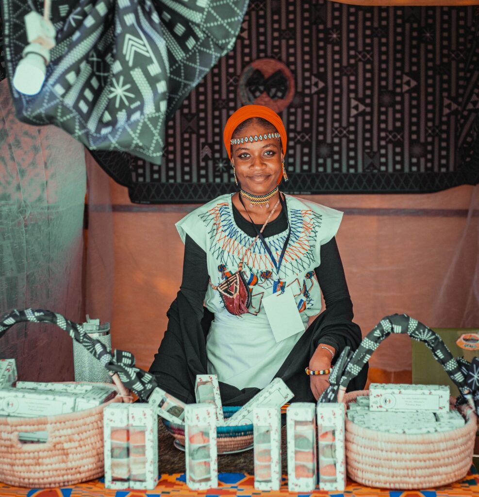 Empreendedora sorridente na sua banca de artesanato